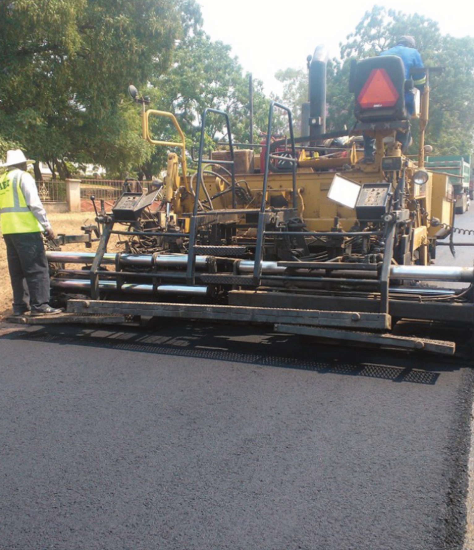 Asphalt paving machine laying fresh road surface