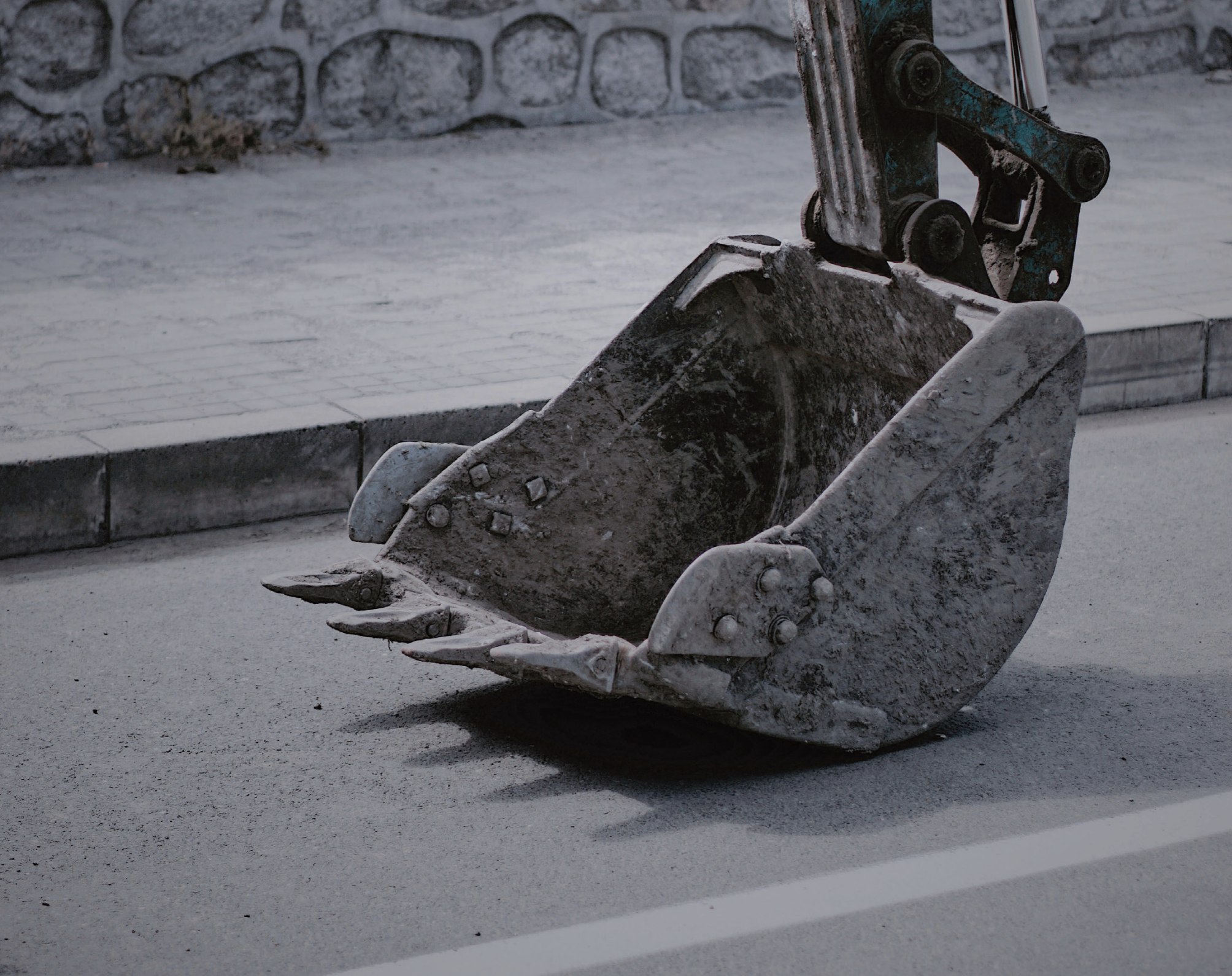 Excavator bucket on paved surface