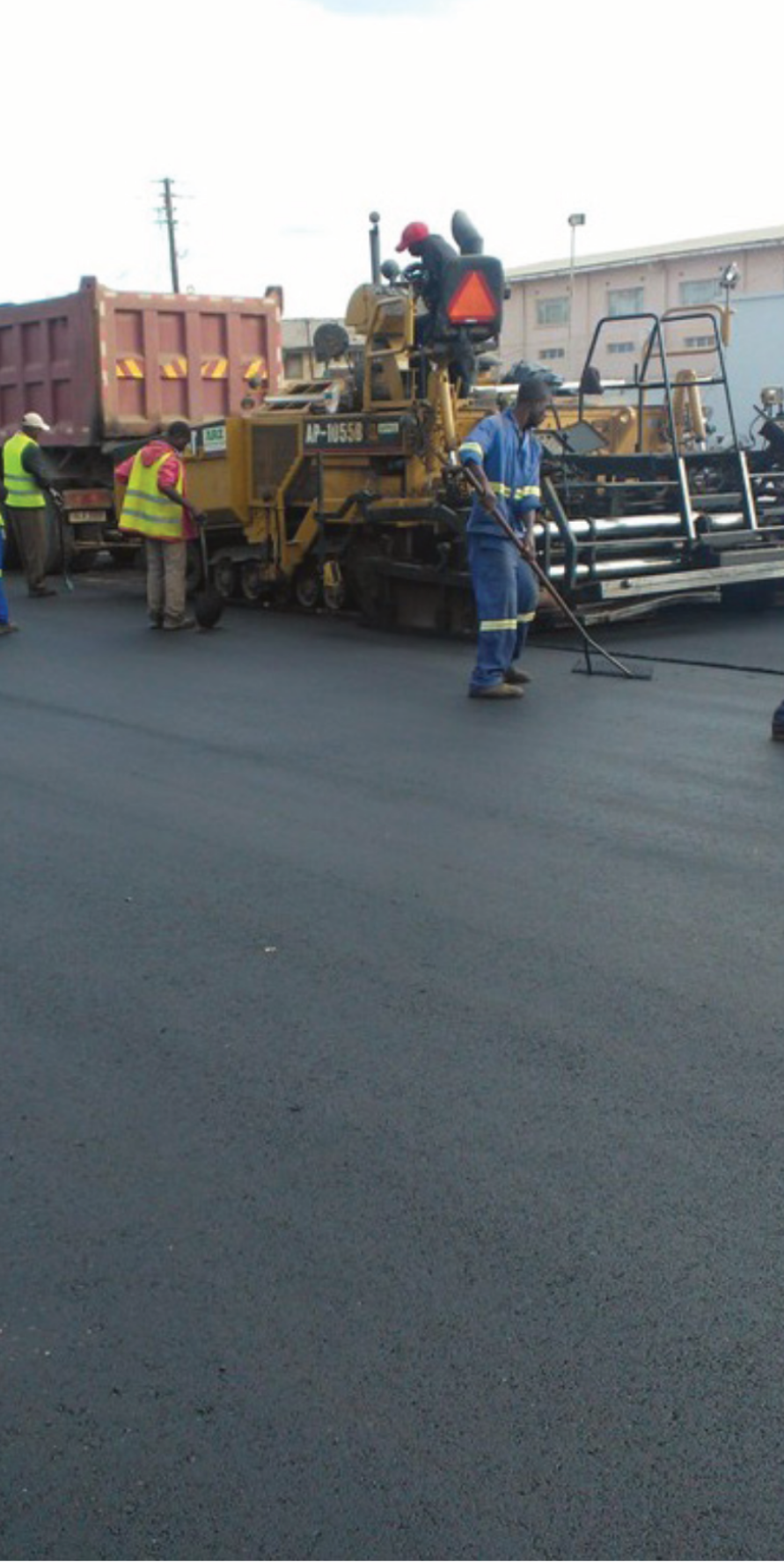 Road paving crew with asphalt paver machine